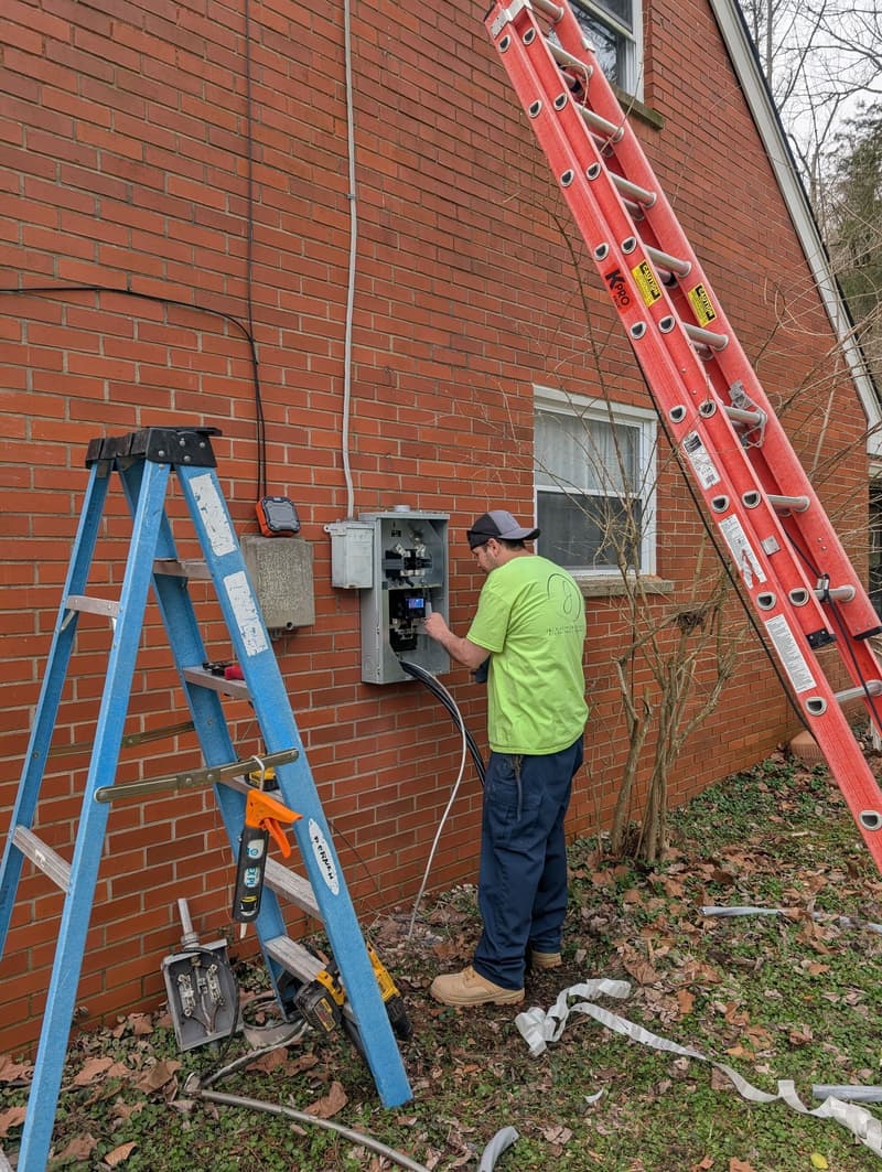 Electrician working at exterior meter and panel